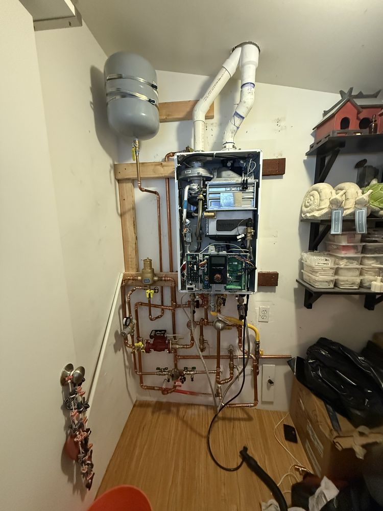Plumbing technician working on an emergency water heater and shutoff repair
